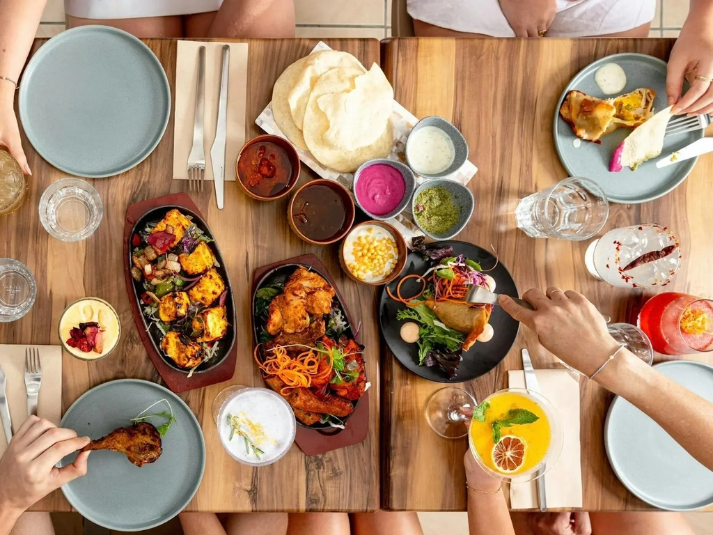 Colourful curries, dips, breads, and hands
