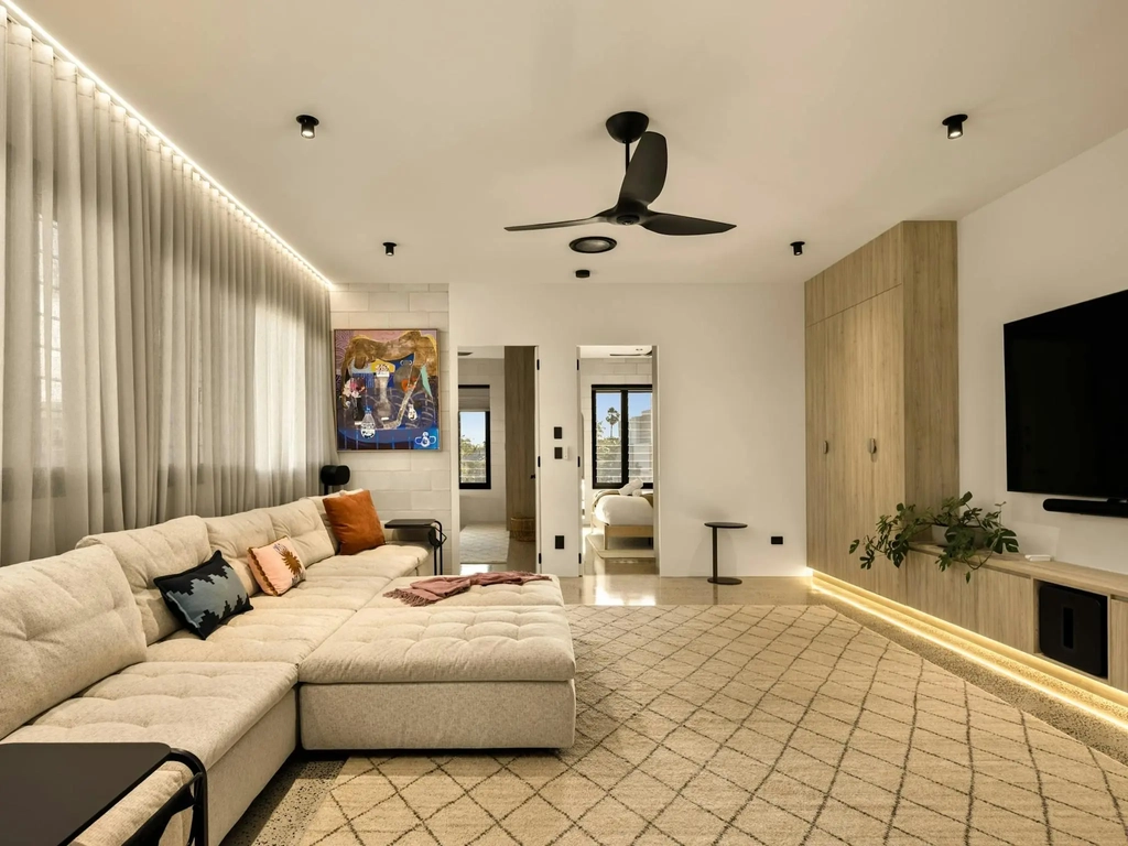 Media room with a large modular lounge facing a screen wall