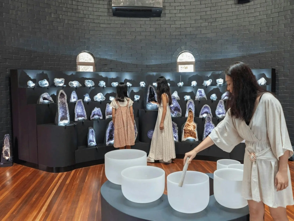 A family looking at Crystal Singing Bowls in the Moon Room at Crystal Castle