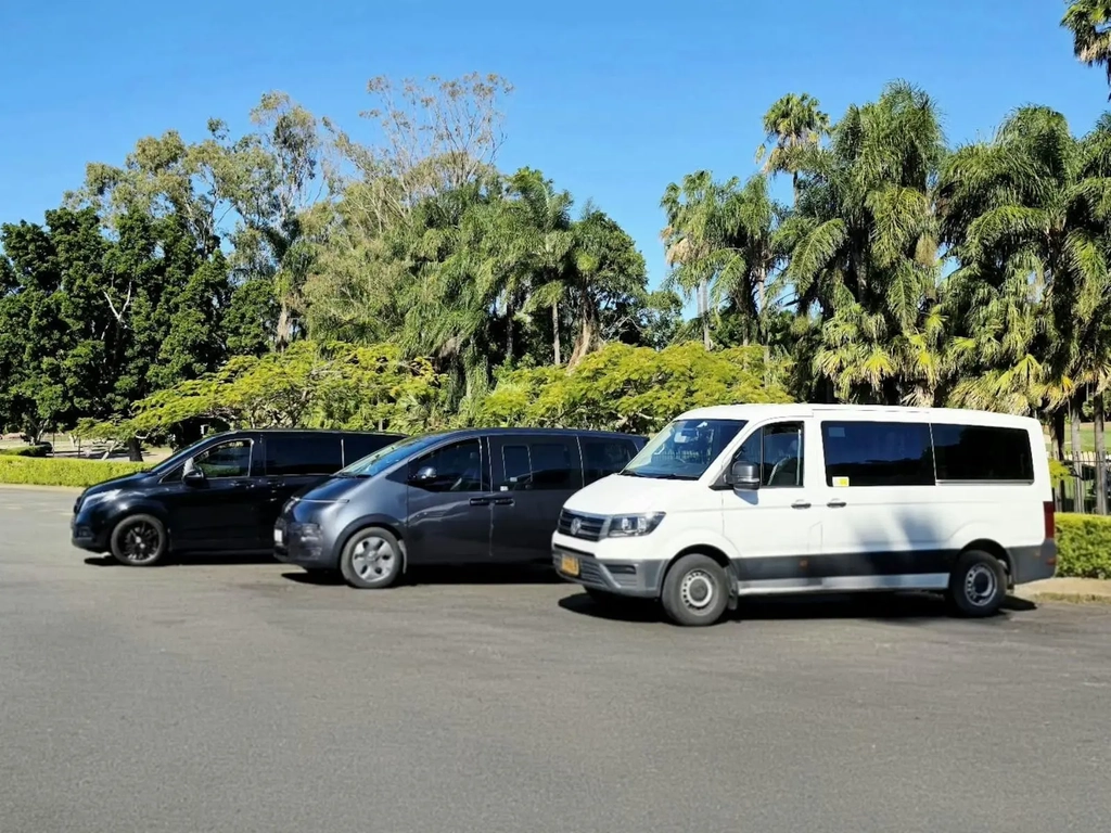 Full fleet of GEC Transfers vans including black, grey, and white vehicles parked