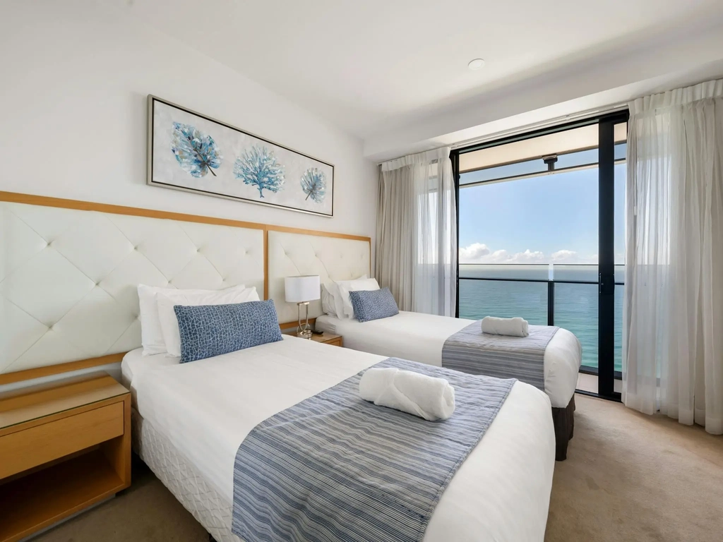 Second bedroom with two single beds and balcony access