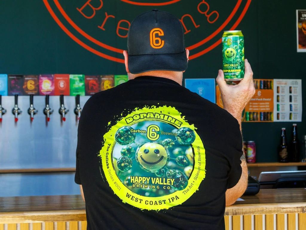 Man standing at a bar with craft beer can in hand