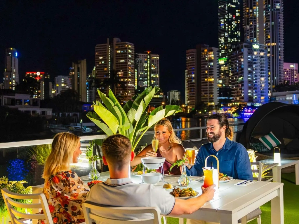 Friends enjoying Buffet Dinner Cruise against Surfers Paradise skyline