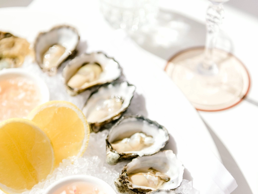 Platter of fresh oysters, lemon and a margarita cocktail.