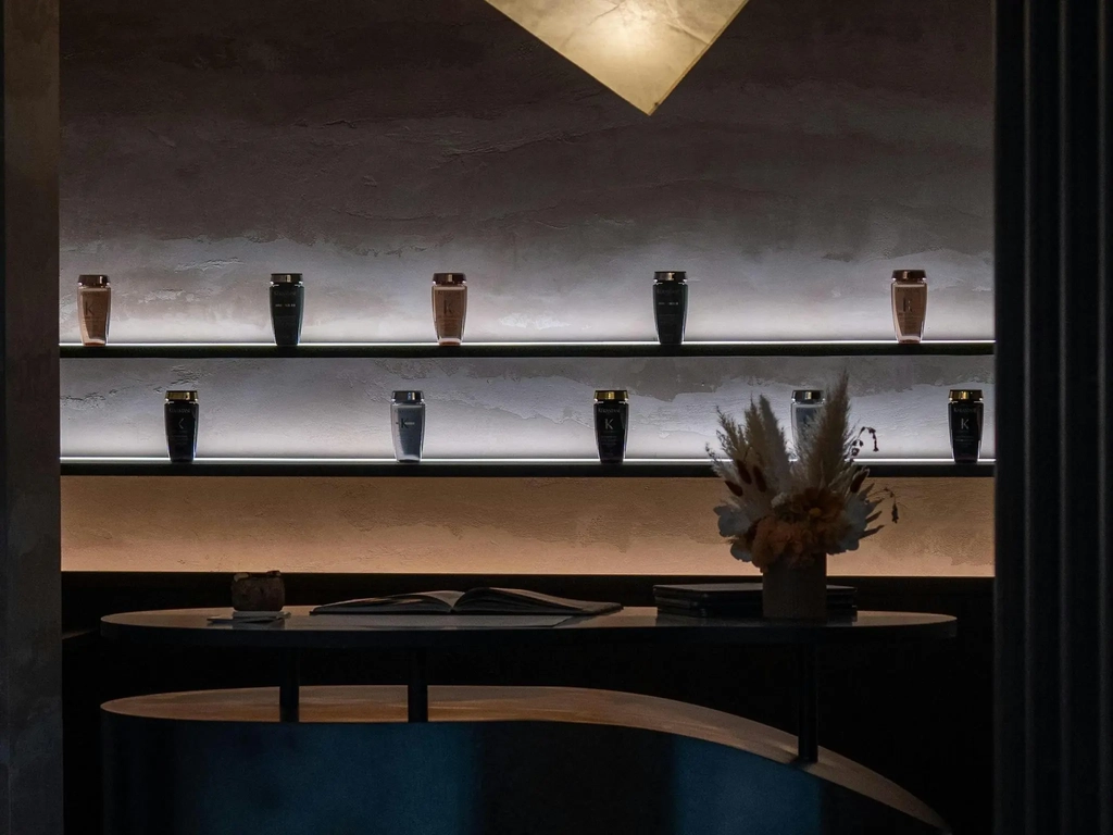 Backlit shelves displaying a full range of Kérastase Paris hair care products at the Yūsen Head Spa