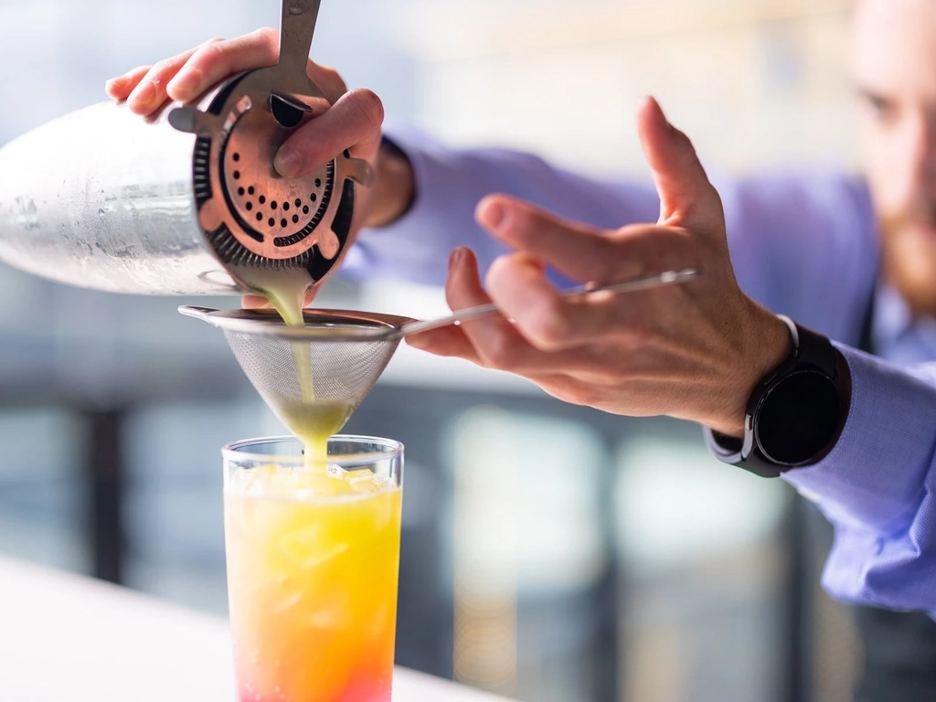 Cocktail being poured at bar