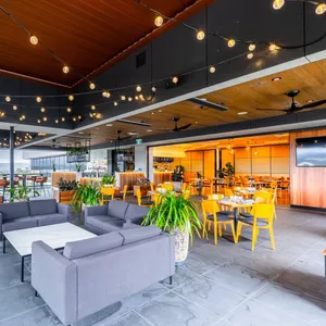 Rooftop area with lounges and tables, festoon lights and hinterland views