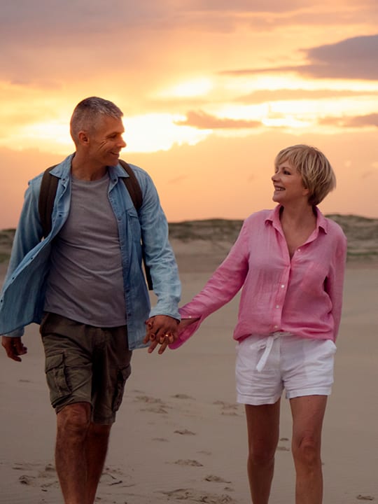 male and female walking on beach