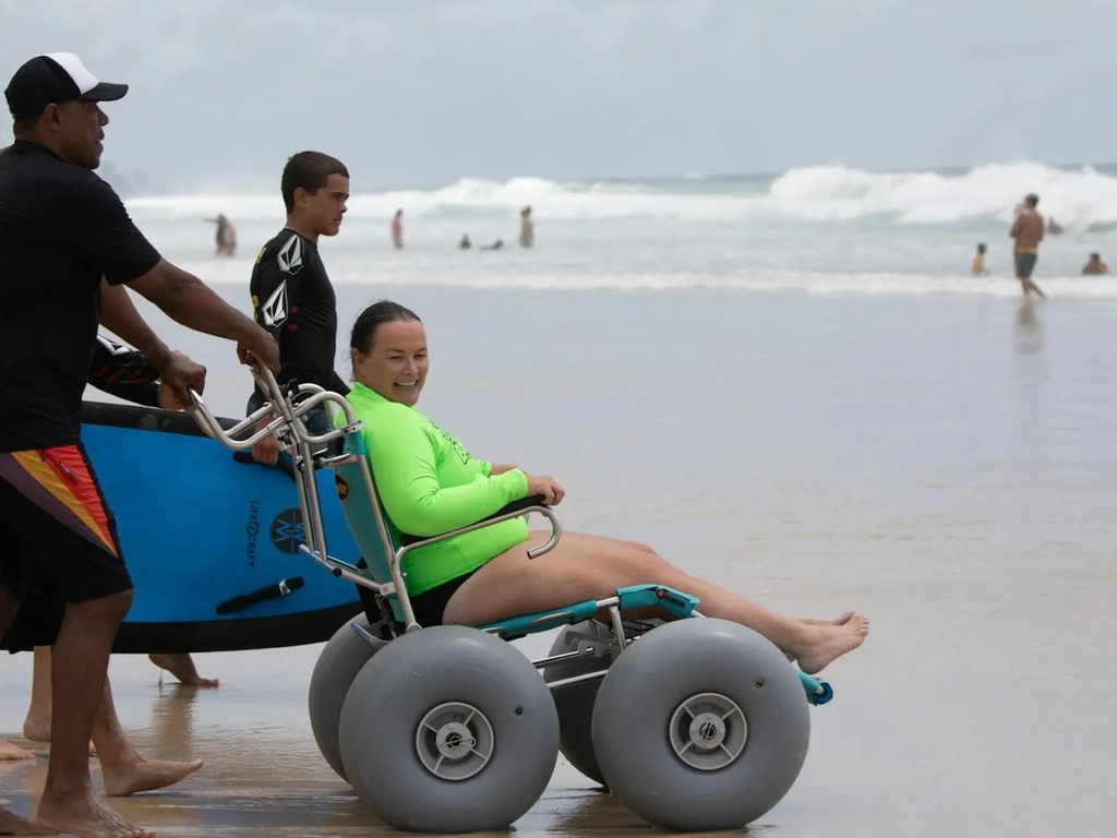 Woamn smiles in beach wheelchair