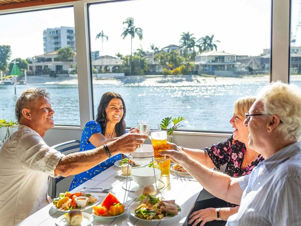 Four friends cheersing at their lunch table on a boat