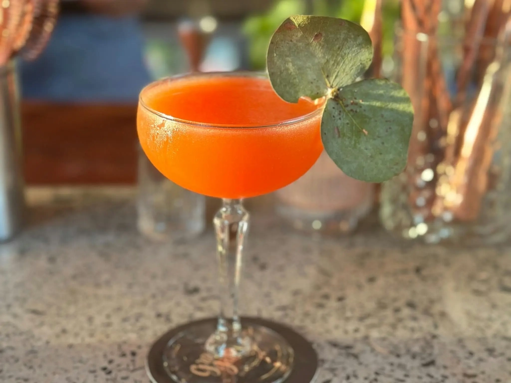 A bright and sweet cocktail sitting on the bar at Granddad Jack's Craft Distillery