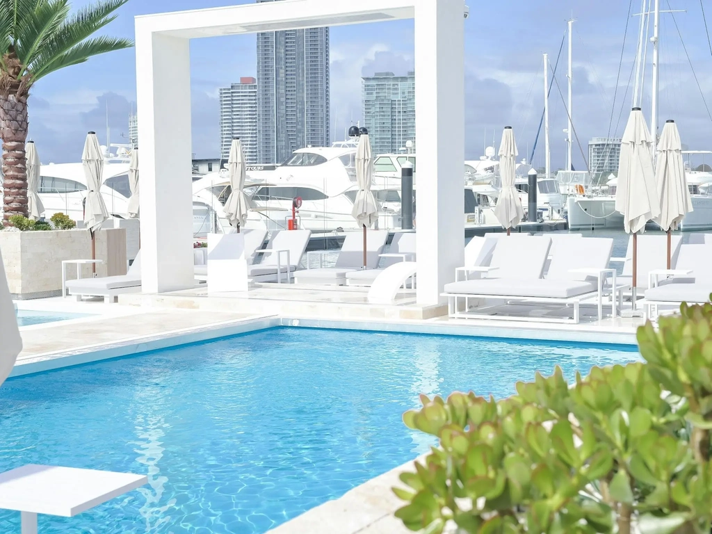 Waterfront atmosphere at La Luna Beach Club with sun lounges, umbrellas and harbour views