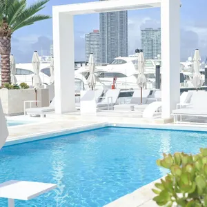 Waterfront atmosphere at La Luna Beach Club with sun lounges, umbrellas and harbour views