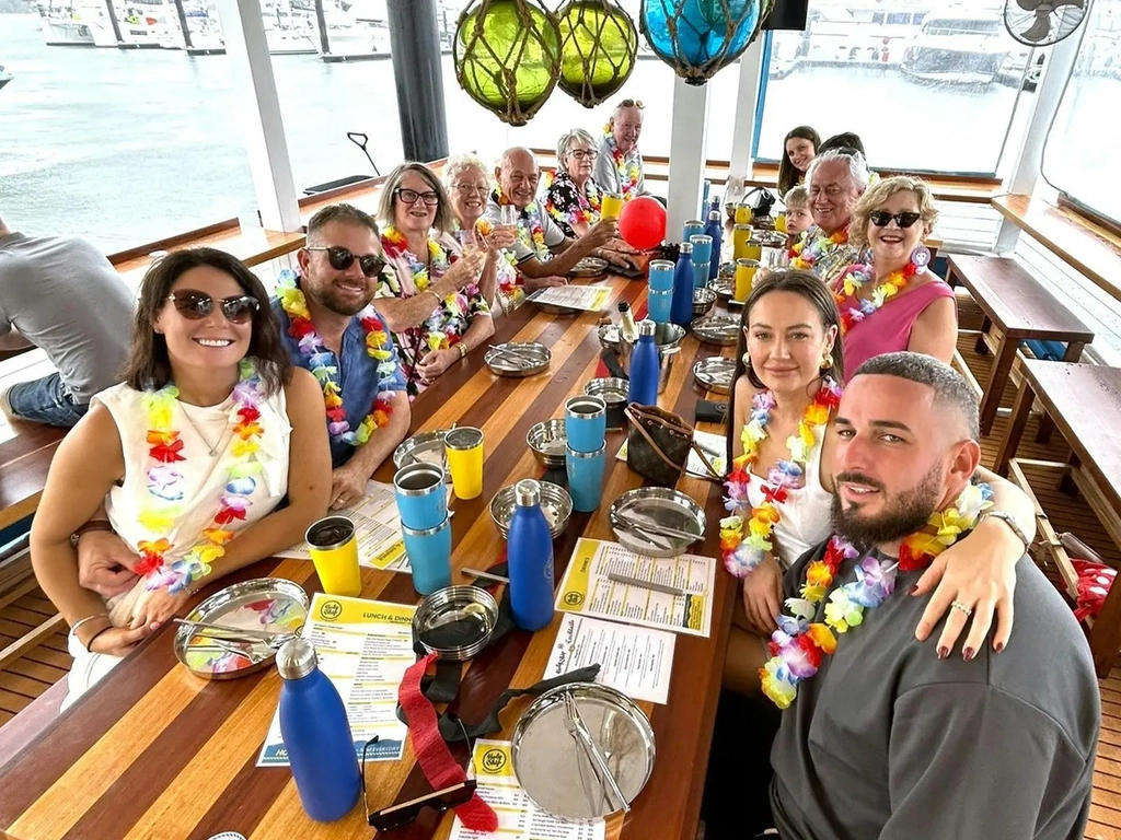 A group of people sitting on Holy Ships Lower deck smiling