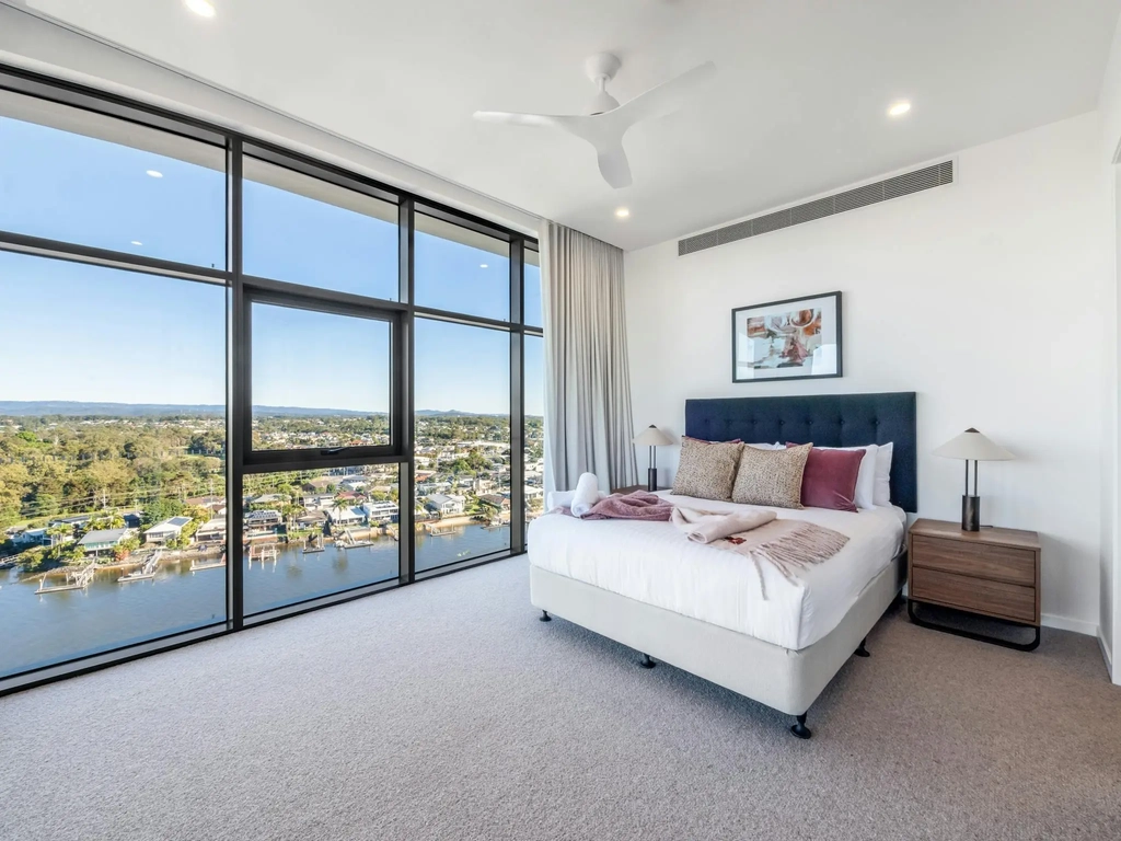 Bedroom with full-height glass and river views