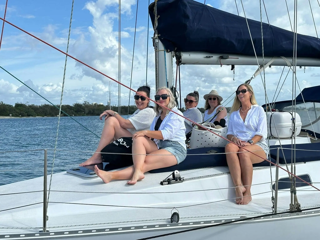 Group of women friends sitting on the deck of Sun Sailing's yacht heading out on an afternoon cruise