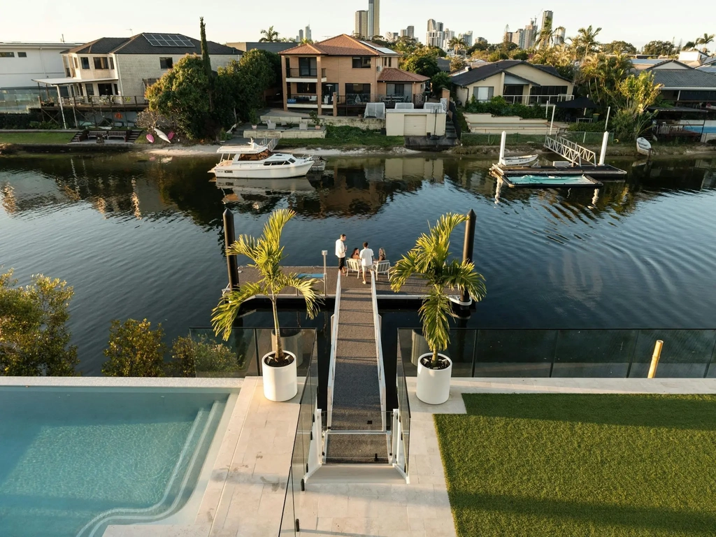 Swimming pool, gangway and private pontoon on a Gold Coast canal at golden hour