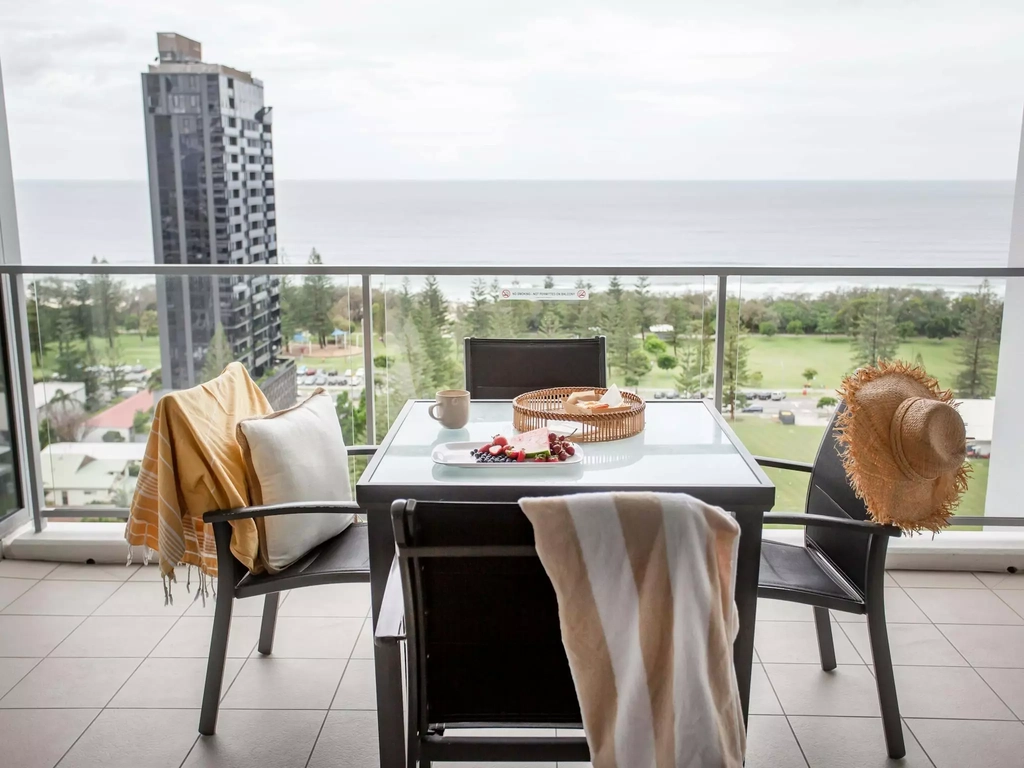 View of table and chairs with towels and hates looking to the beach