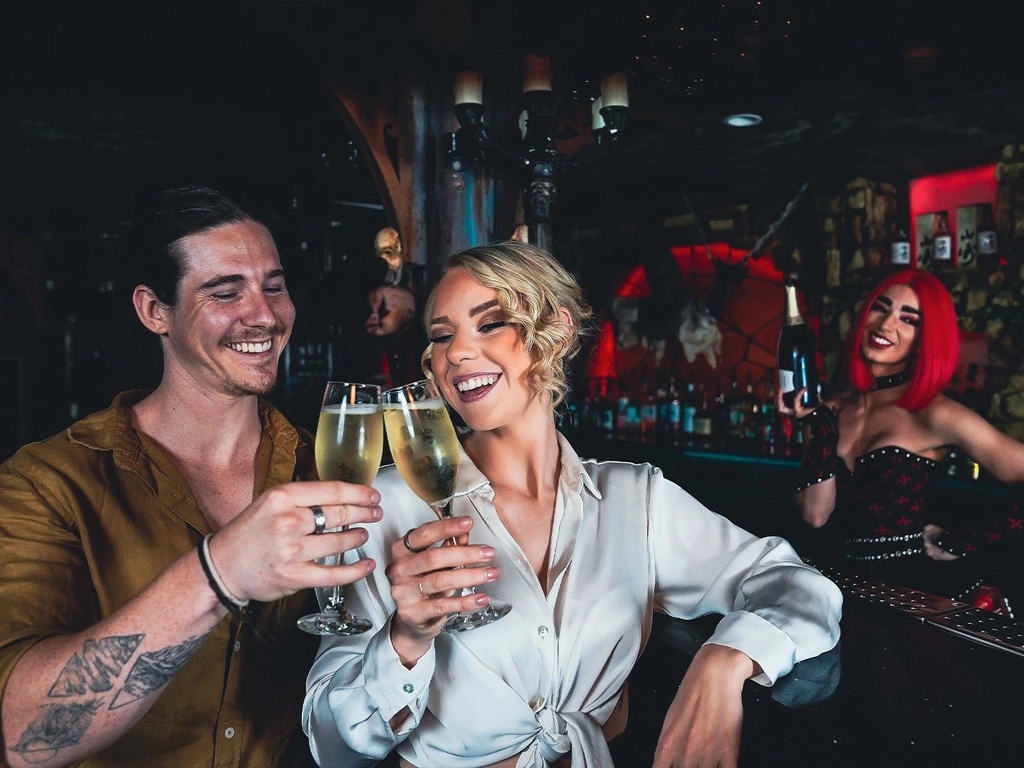 Male and female customers enjoy a glass of champagne at the Dracula's bar.