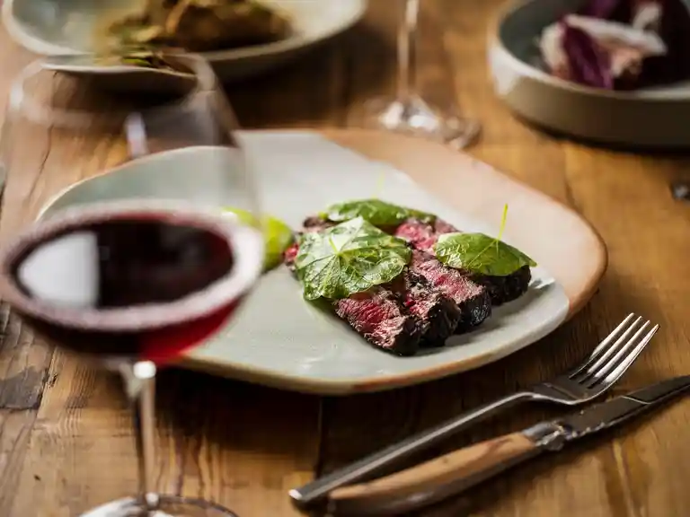 Wagyu dish accompanied by a glass of red wine