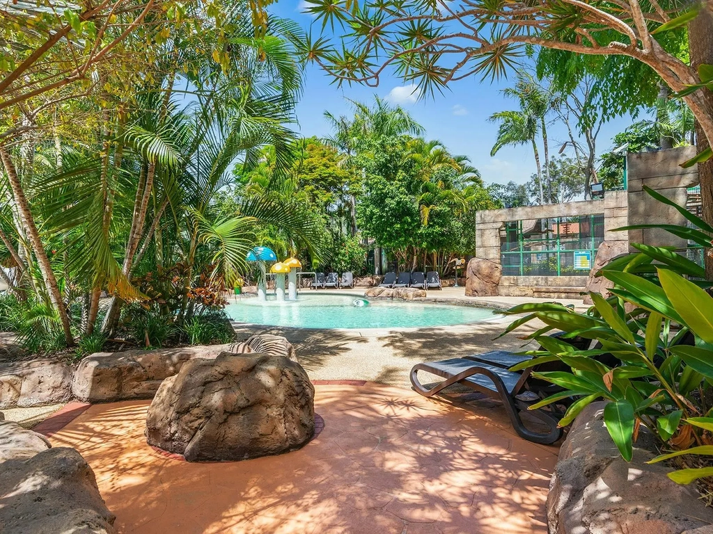 A tropical kids lagoon pool with shady palm trees