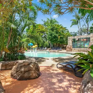 A tropical kids lagoon pool with shady palm trees