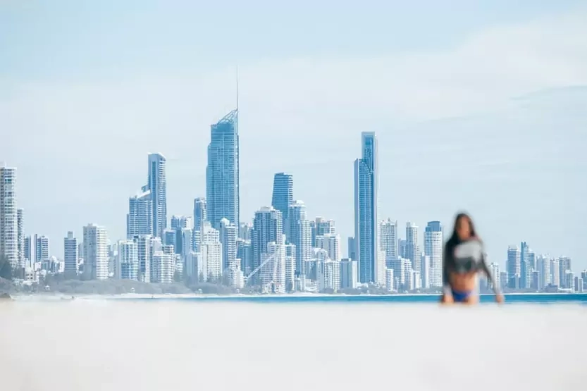 girl-stretching-on-the-beach-and-surfers-paradise-skyline-1-66303bc74a9bd.webp